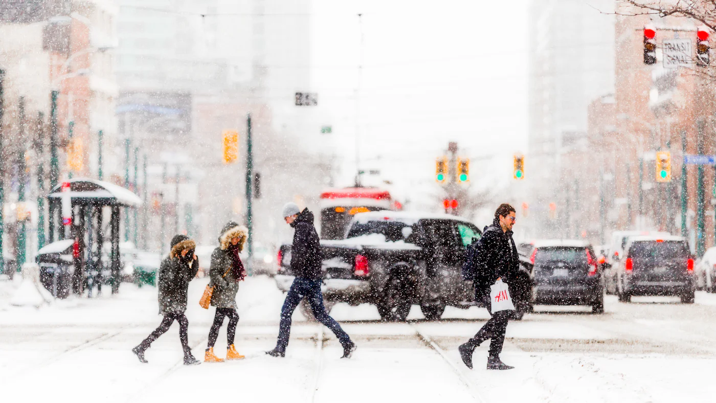 People walking a snow-covered street in daylight