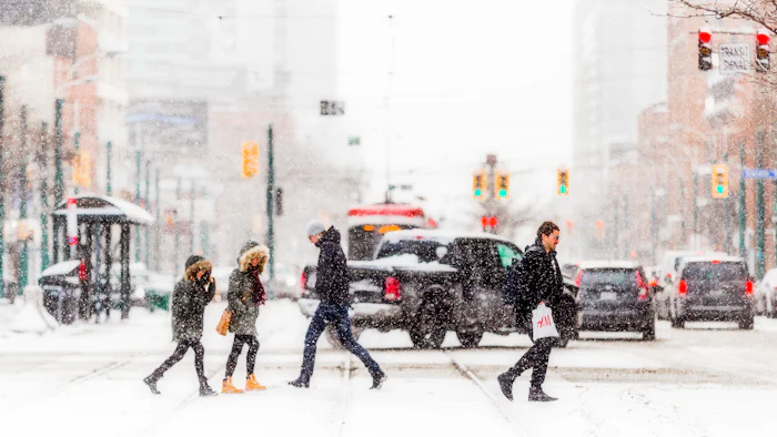 People walking a snow-covered street in daylight