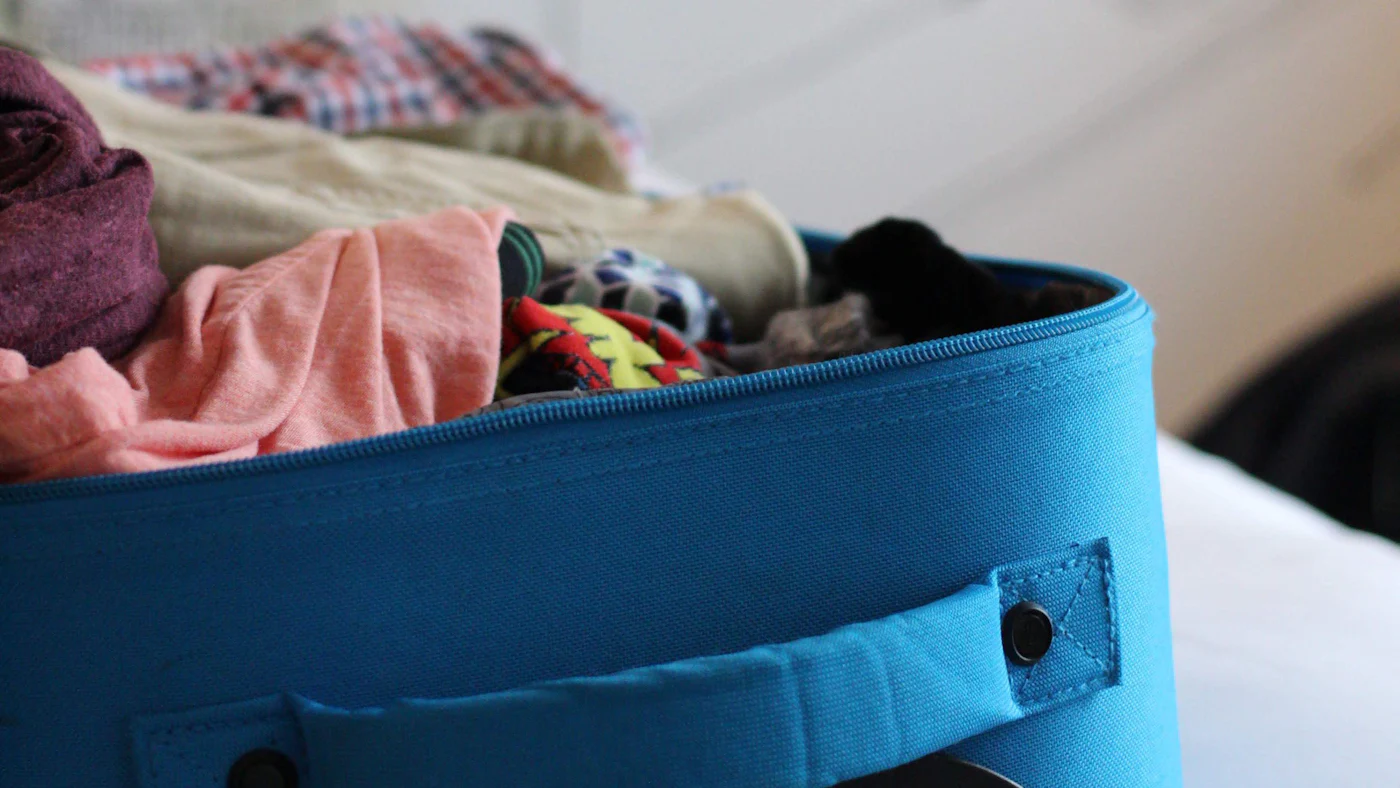 An open suitcase packed with clothes