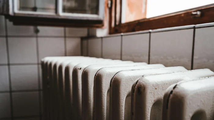 A radiator beneath a window in a warm room