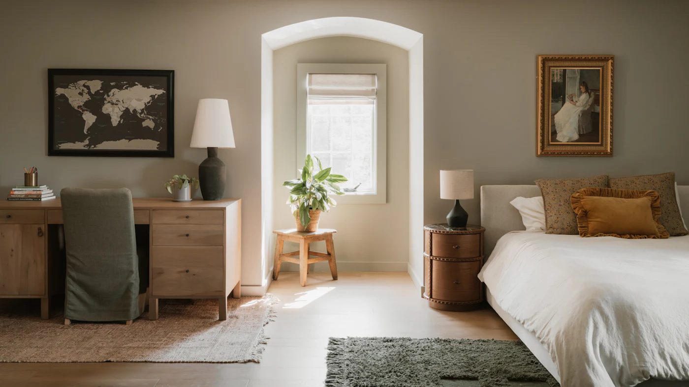 A bright bedroom with a desk and a large bed